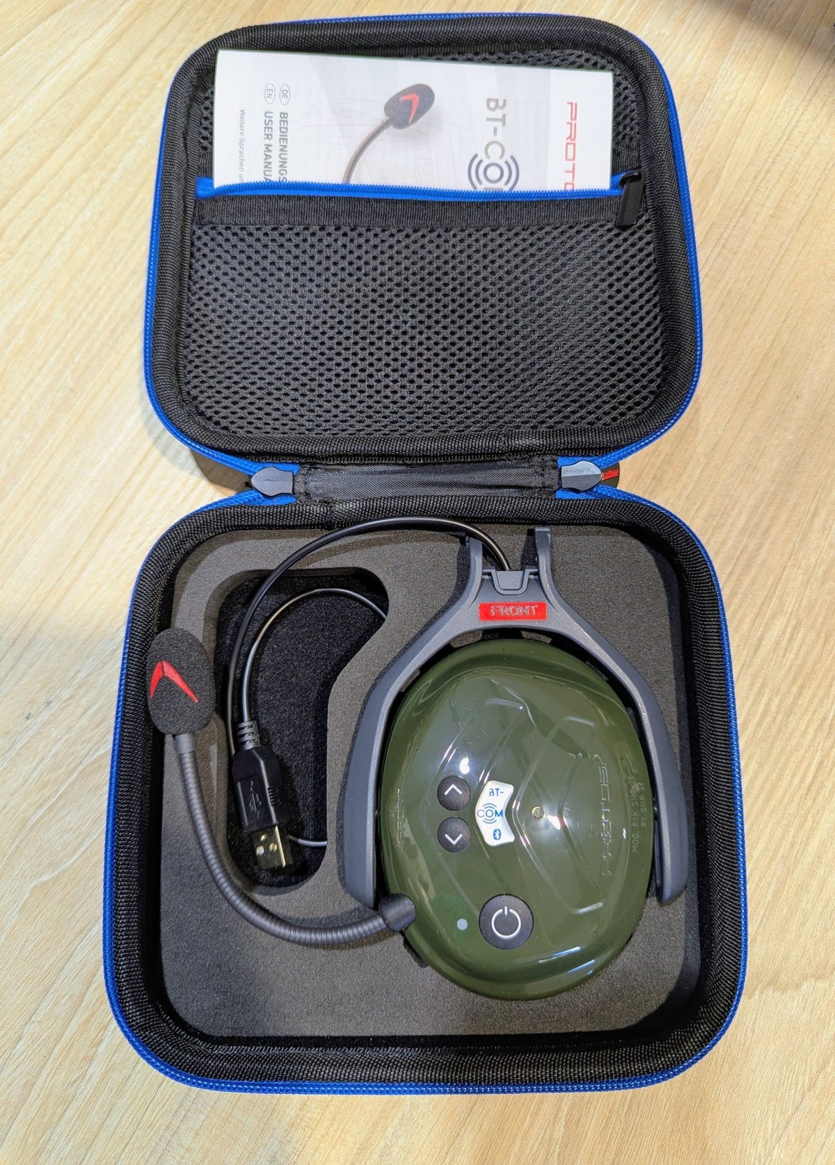 Das olivgrüne Protos BT COM in der geöffneten Originalverpackung