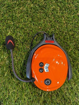 Das Protos BT COM in orange ohne Verpackung auf grünem Rasen